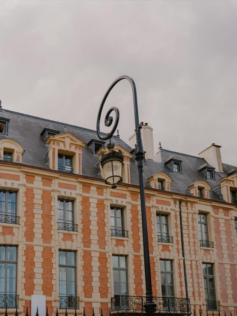 Immeuble de brique avec lanterne en fer forg&eacute; au premier plan.