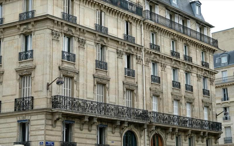 Enfilade de toits parisiens sous un ciel clair.
